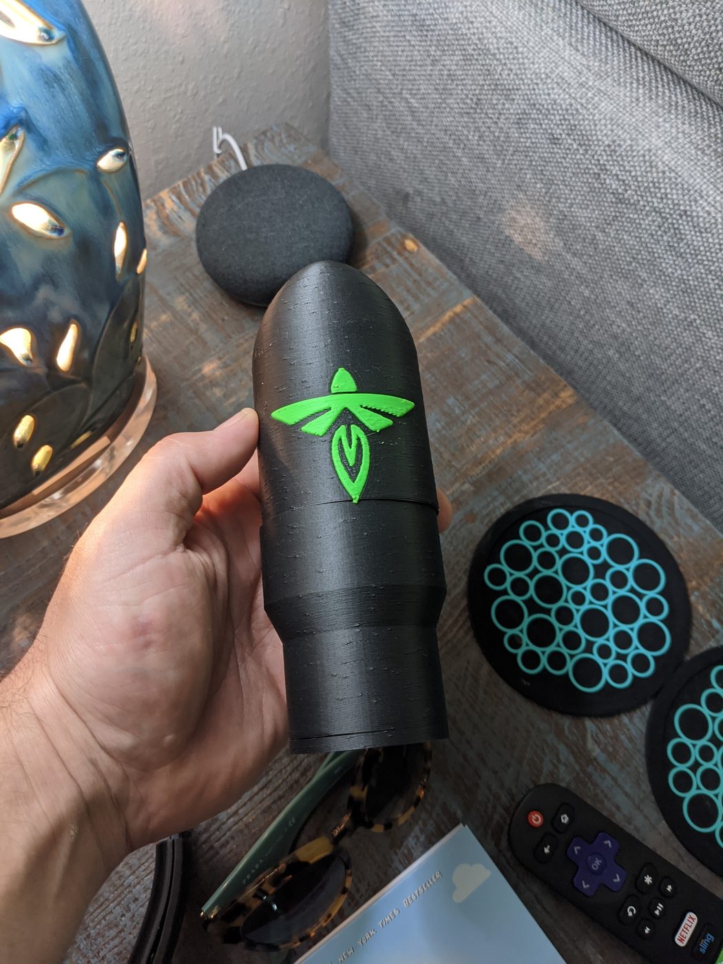 Black 3D-printed cylindrical enclosure on a workbench