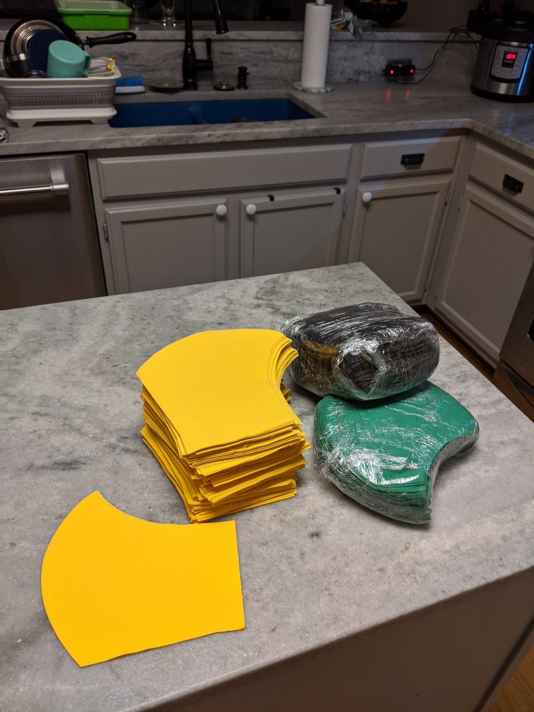 Laser-cut yellow fabric mask pieces on the kitchen counter